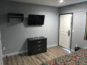 Empire Inn LAX - Wall-Mounted Flat Screen TVs with Clothes Rack in Rooms